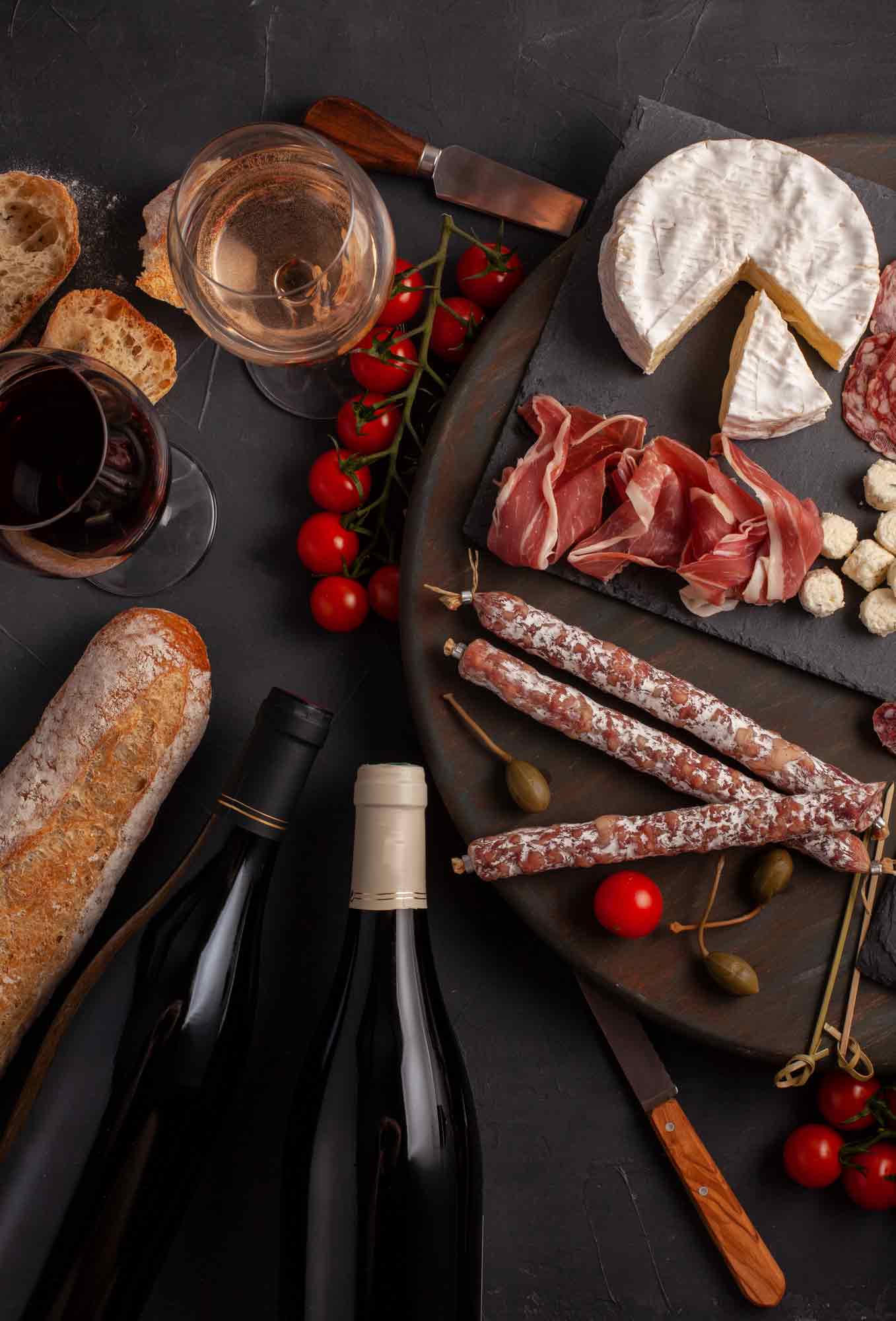 tabla de embutidos acompañada de vinos y pan